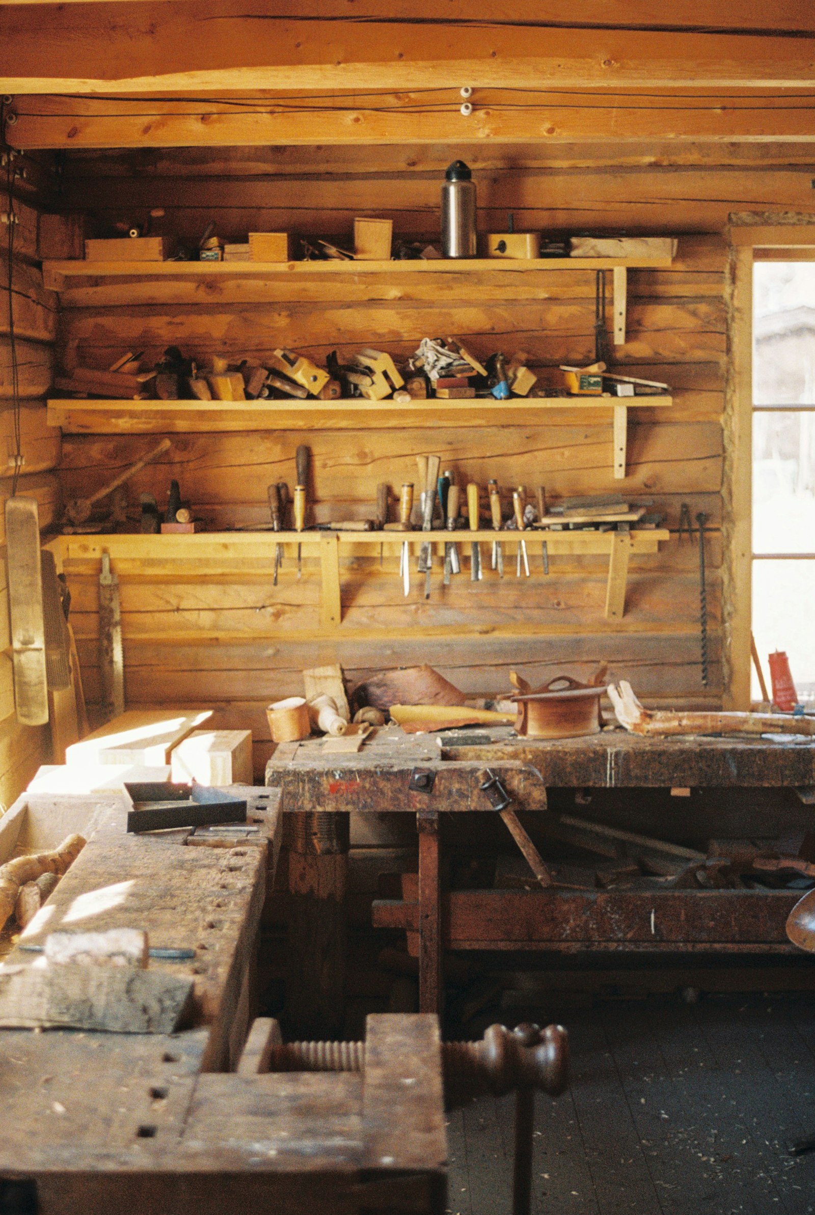 Établi en bois d’un atelier d’artisan avec ses outils accrochés au mur