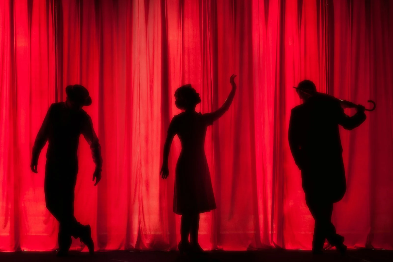 Silhouettes de trois artistes sur une scène