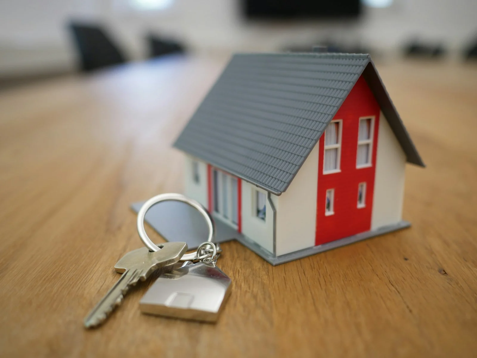 Petite maquette de maison en bois posée sur un bureau