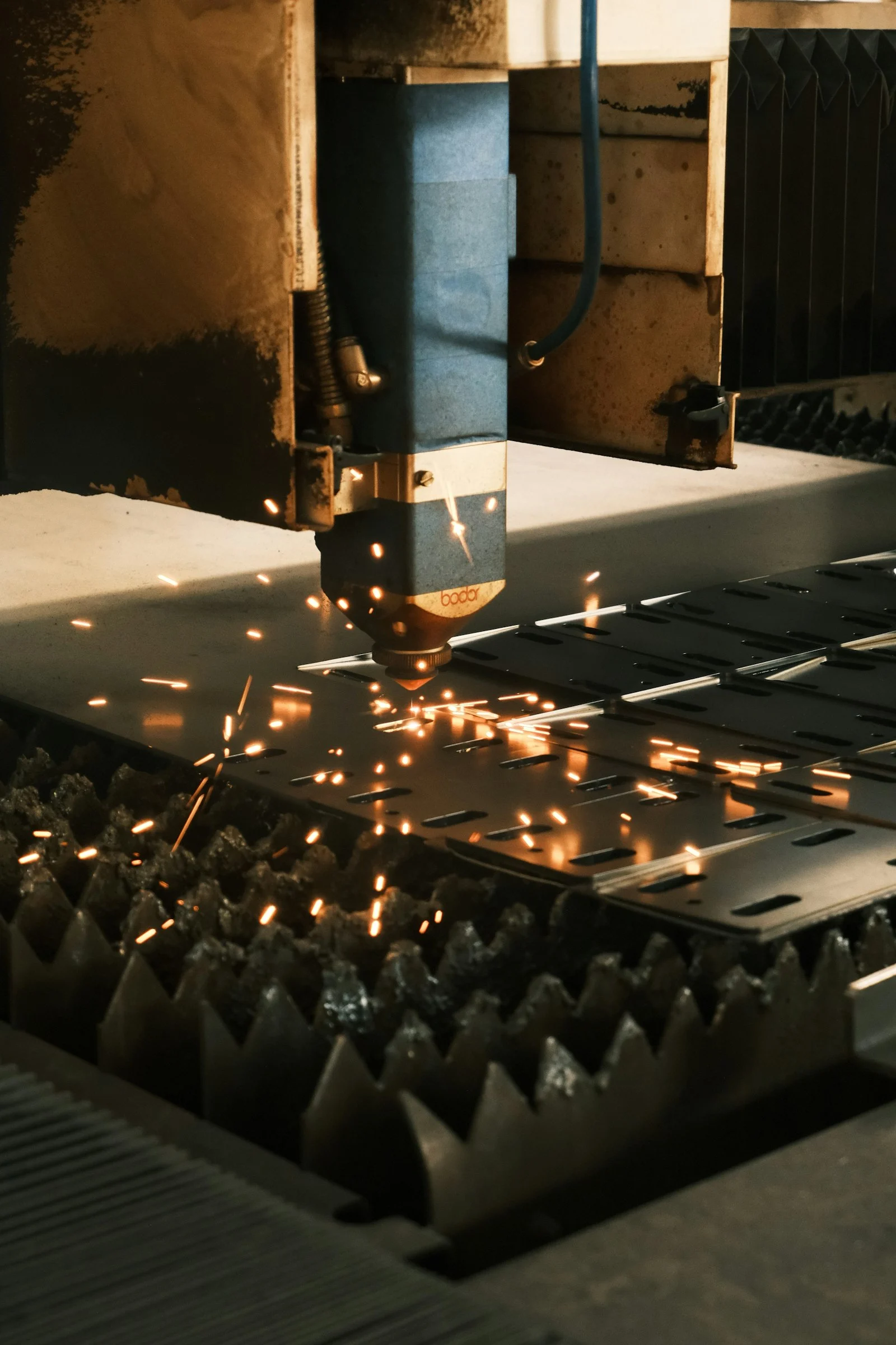 Machine qui découpe une pièce de métal dans une gerbe d’étincelles